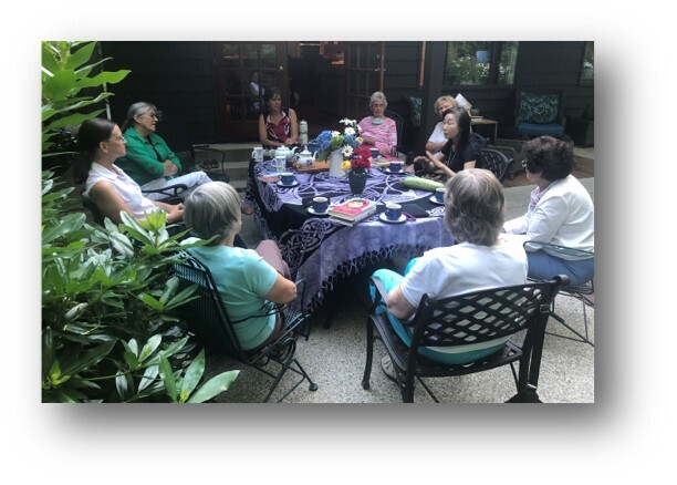 Book Club sitting around a table in a garden