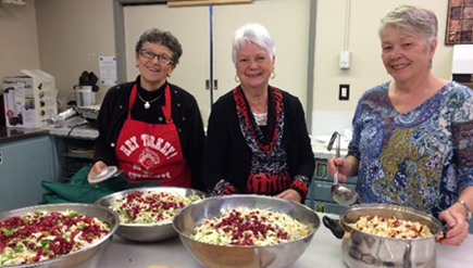 Volunteers preparing salads in the kitchen at Highlands