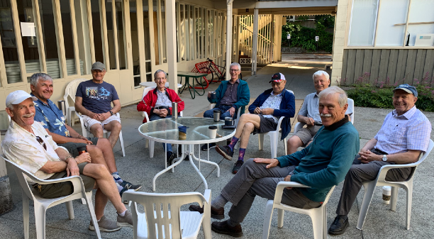 Men sitting around a table chatting